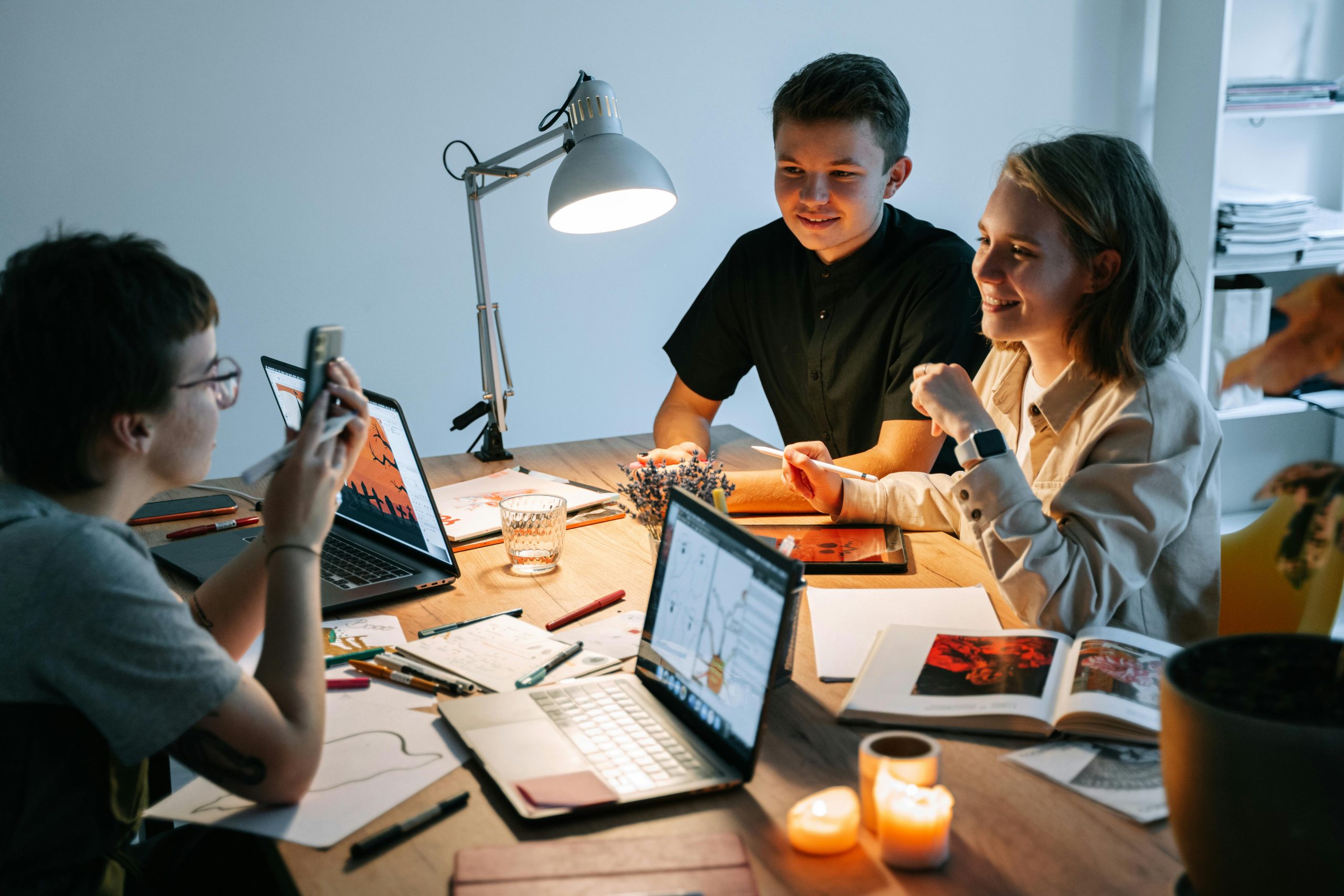 Colleagues talking with laptops on table